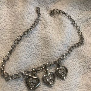 Silver tone bracelet with three hearts